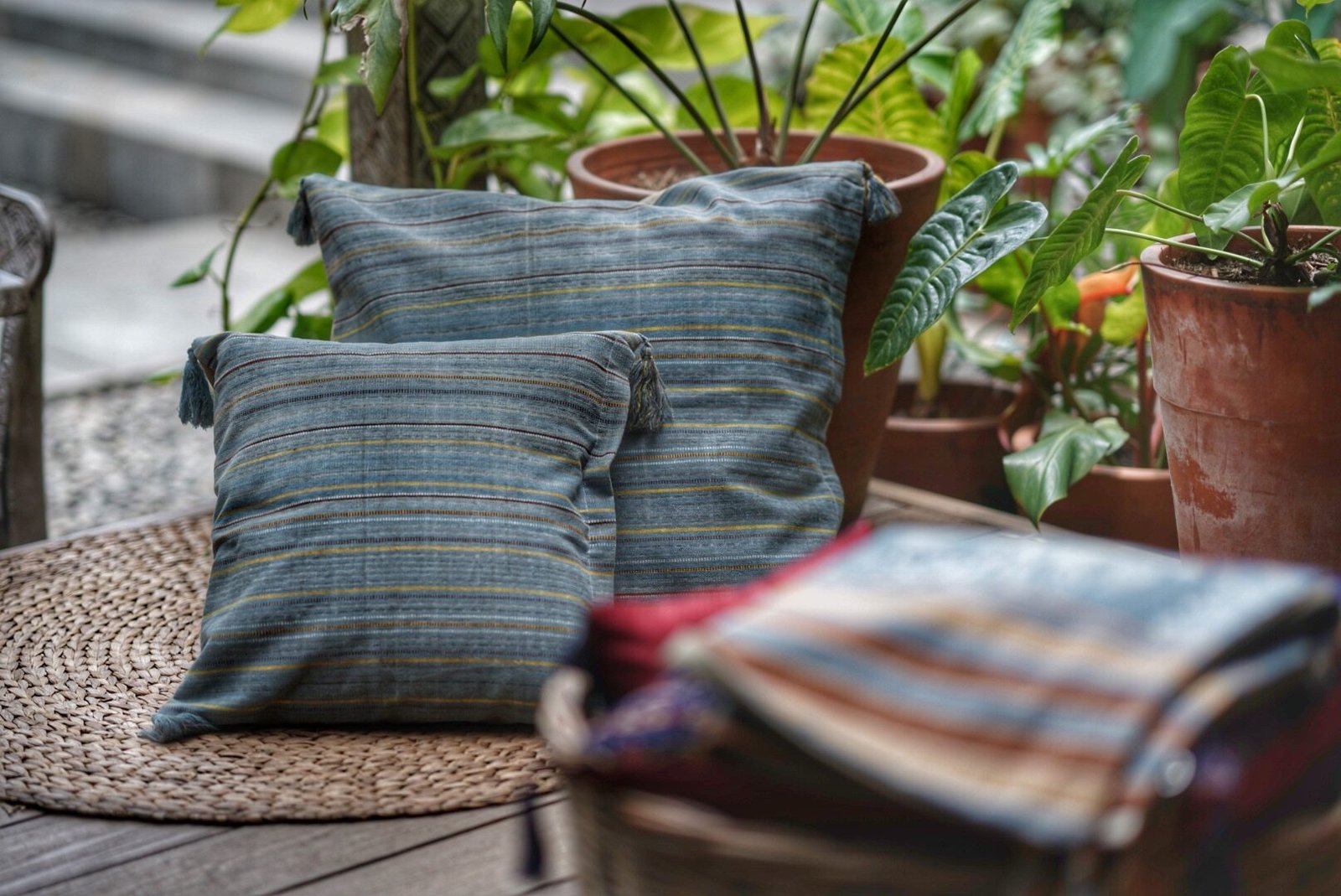 Ikat cushions and folded cloth styled among plants at Lafaina Ikat Gallery
